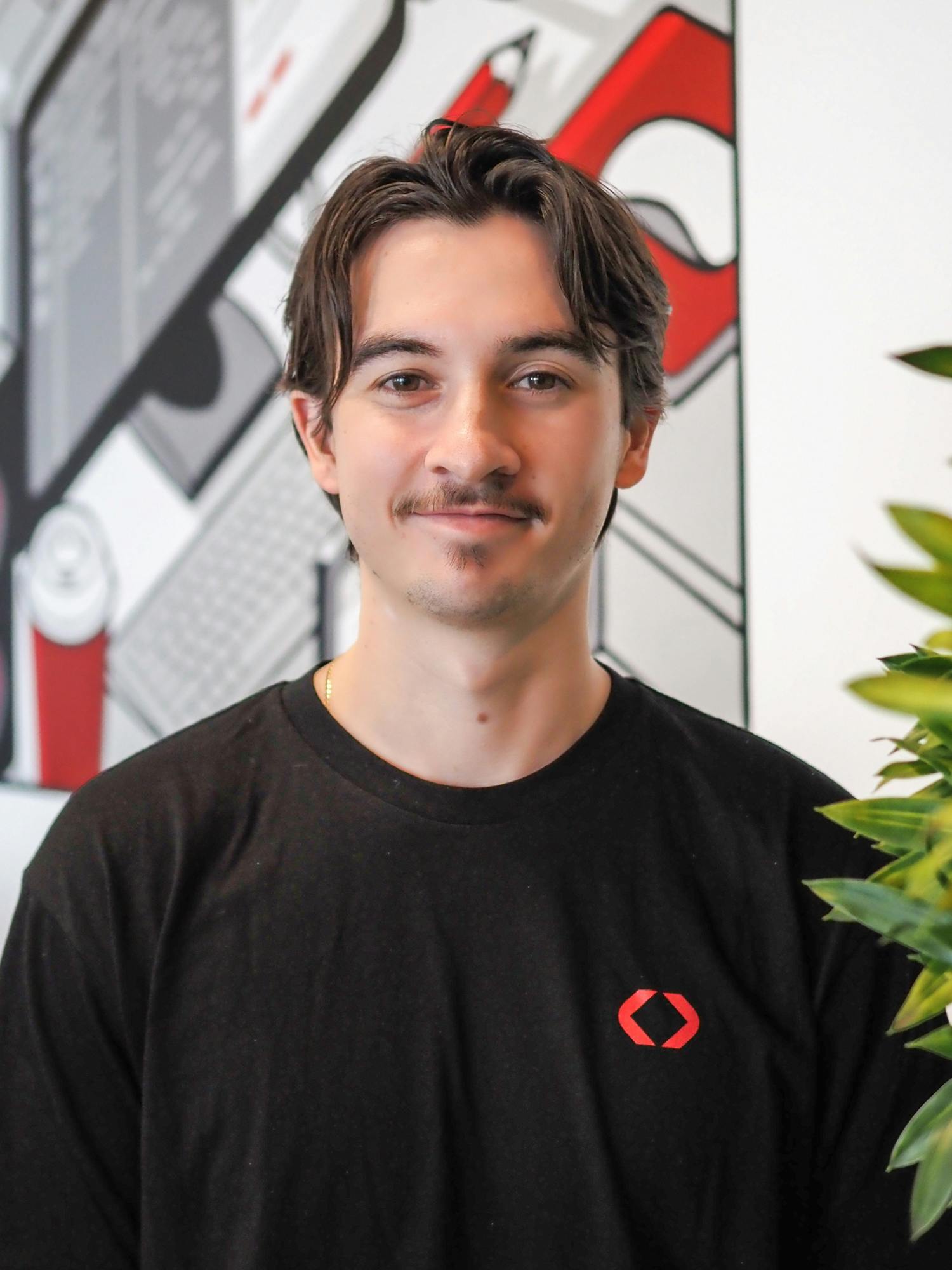 a man wearing a black shirt with a red x on it