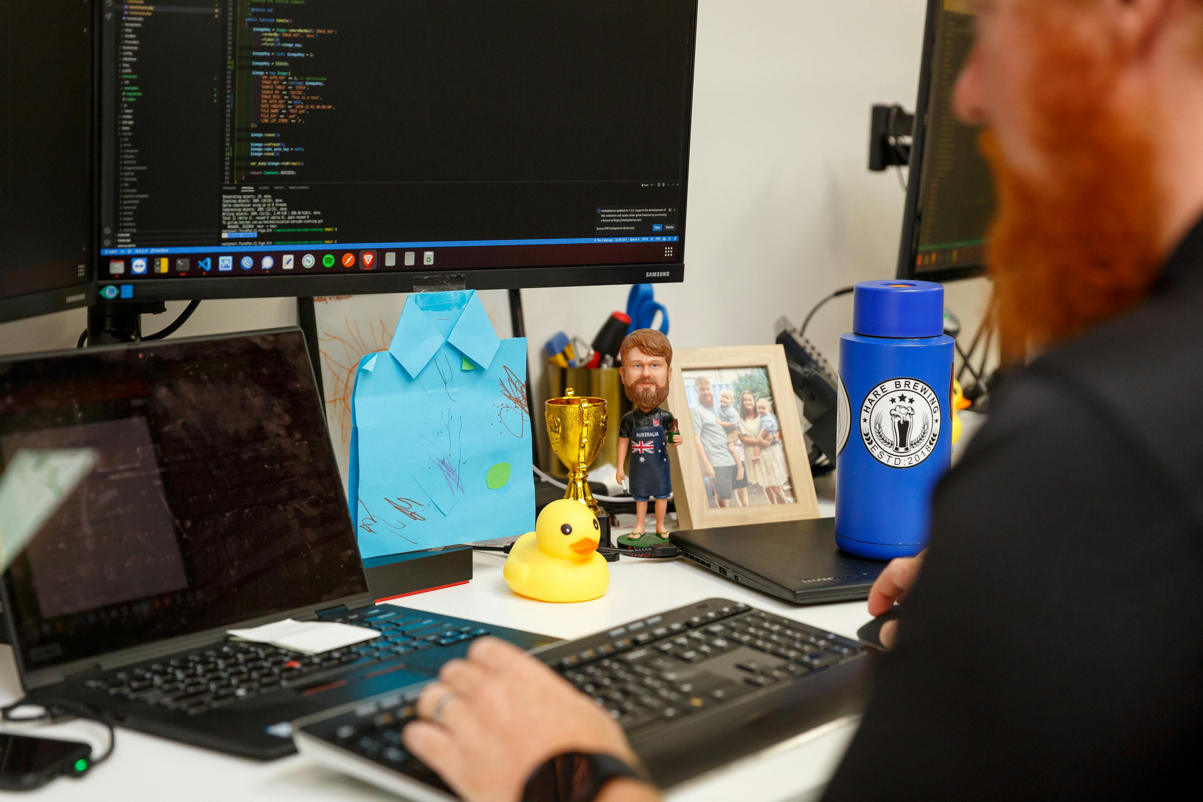 a man is sitting at a desk typing on a laptop computer .